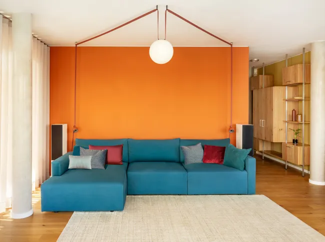Wohnzimmer orange Wand Wohnung Berlin conscious design interiors